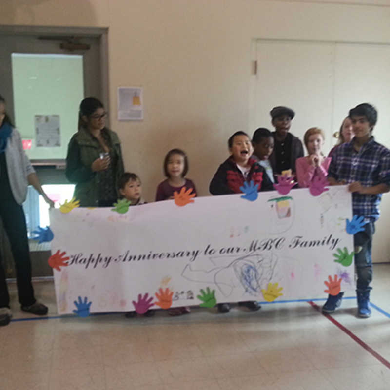 Children holding their anniversary banner