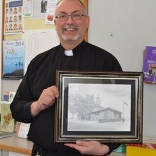 Father Ian with the original calendar photo of Sacred Heart Church, Oyen
