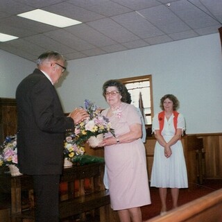 Mother receiving flowers from Preacher Cody for the oldest mother. (1986)